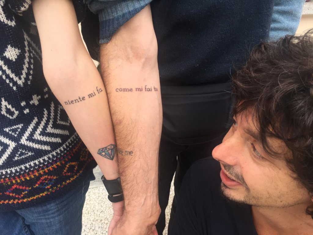 Riccardo Sinigallia guarda il tatuaggio di Marco e Laura